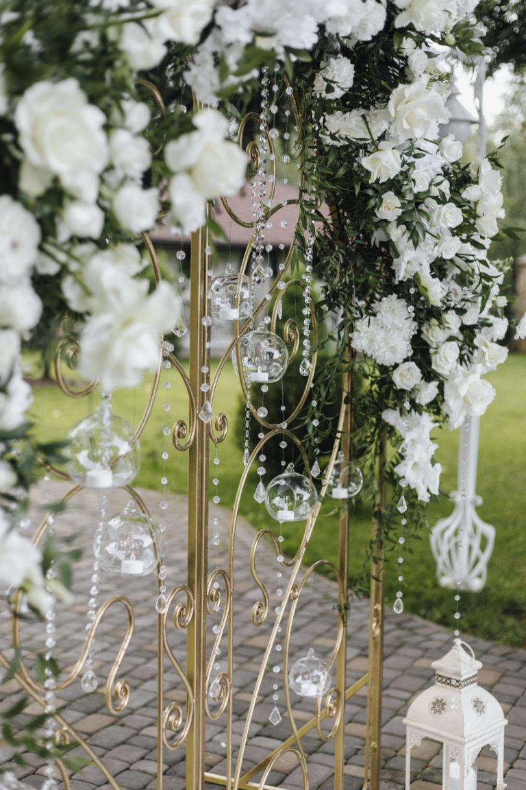 Forged gates are decorated with fresh white flowers and greenery, close up